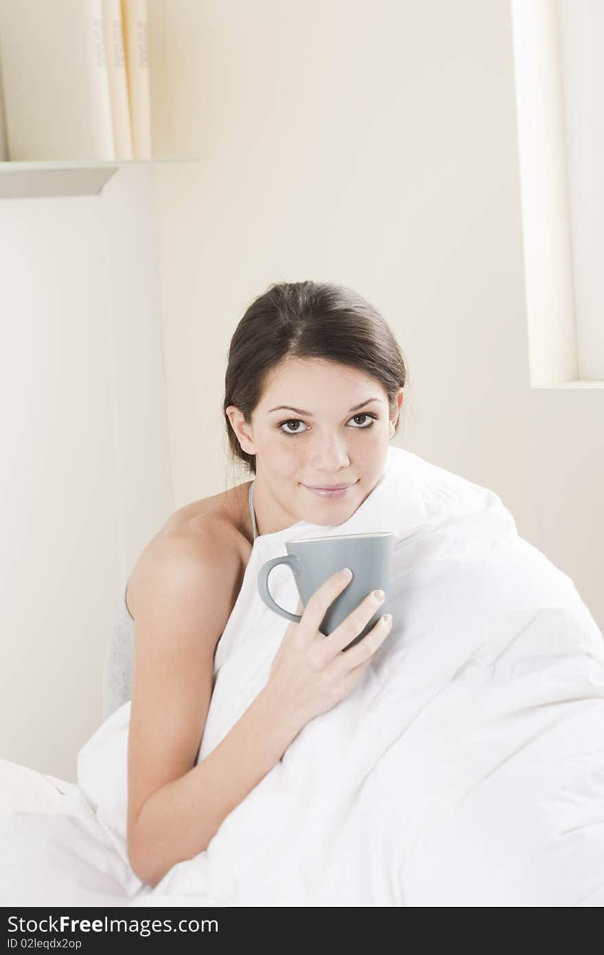 Young woman having breakfast in her bed