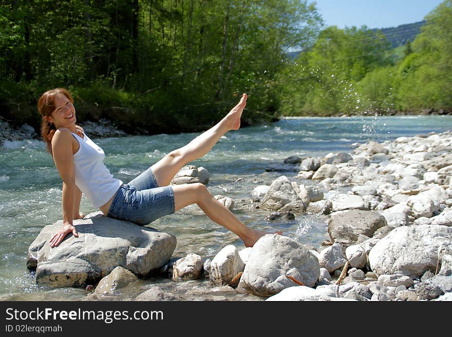 A woman enjoys the cooling on a cold River. A woman enjoys the cooling on a cold River.