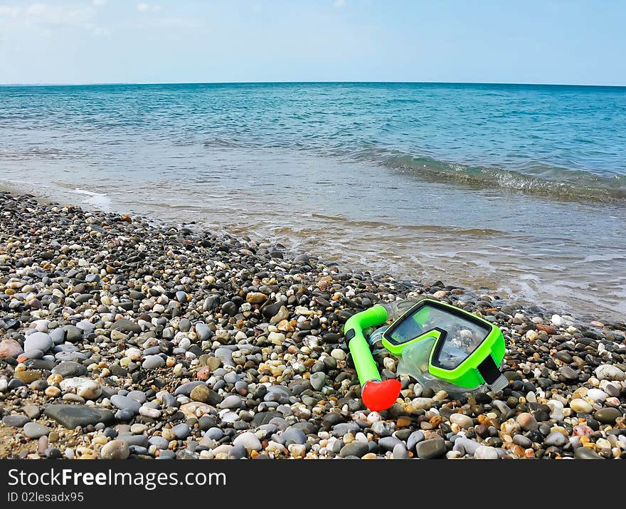 Mask and tube for a scuba diving lying on the bank of Black sea in Crimea