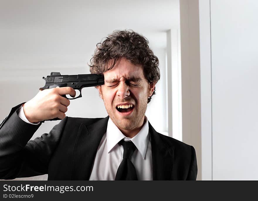 Businessman pointing a gun against his head. Businessman pointing a gun against his head