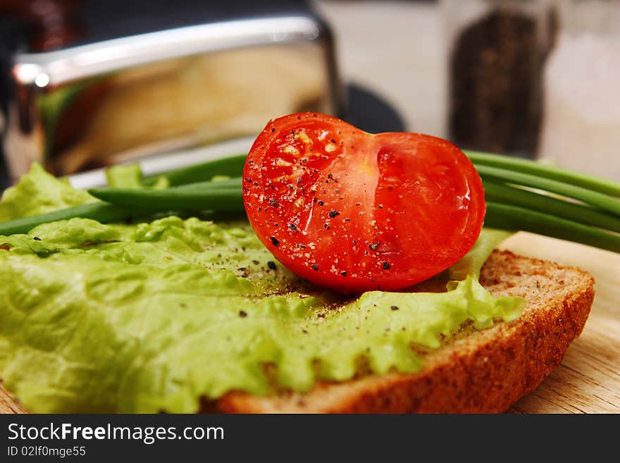 Sandwich with salad leaves, an onions and a tomato