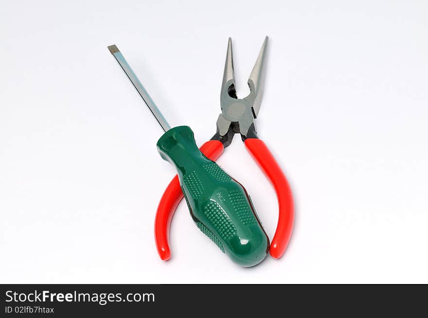 Red handle pliers and screwdrive on a white background . Red handle pliers and screwdrive on a white background .