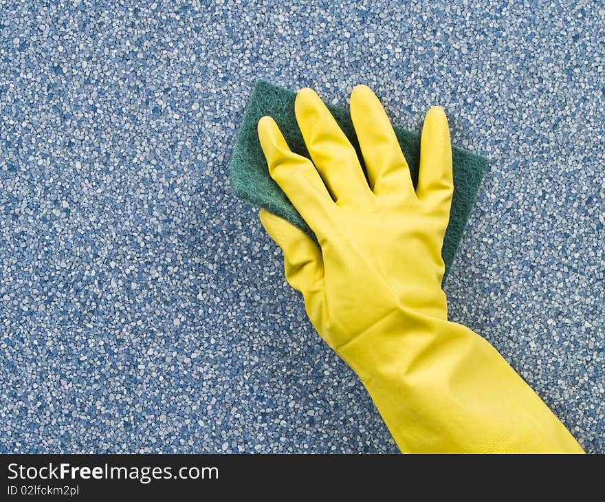 Hand in yellow glove holding green sponge and washing table. Hand in yellow glove holding green sponge and washing table