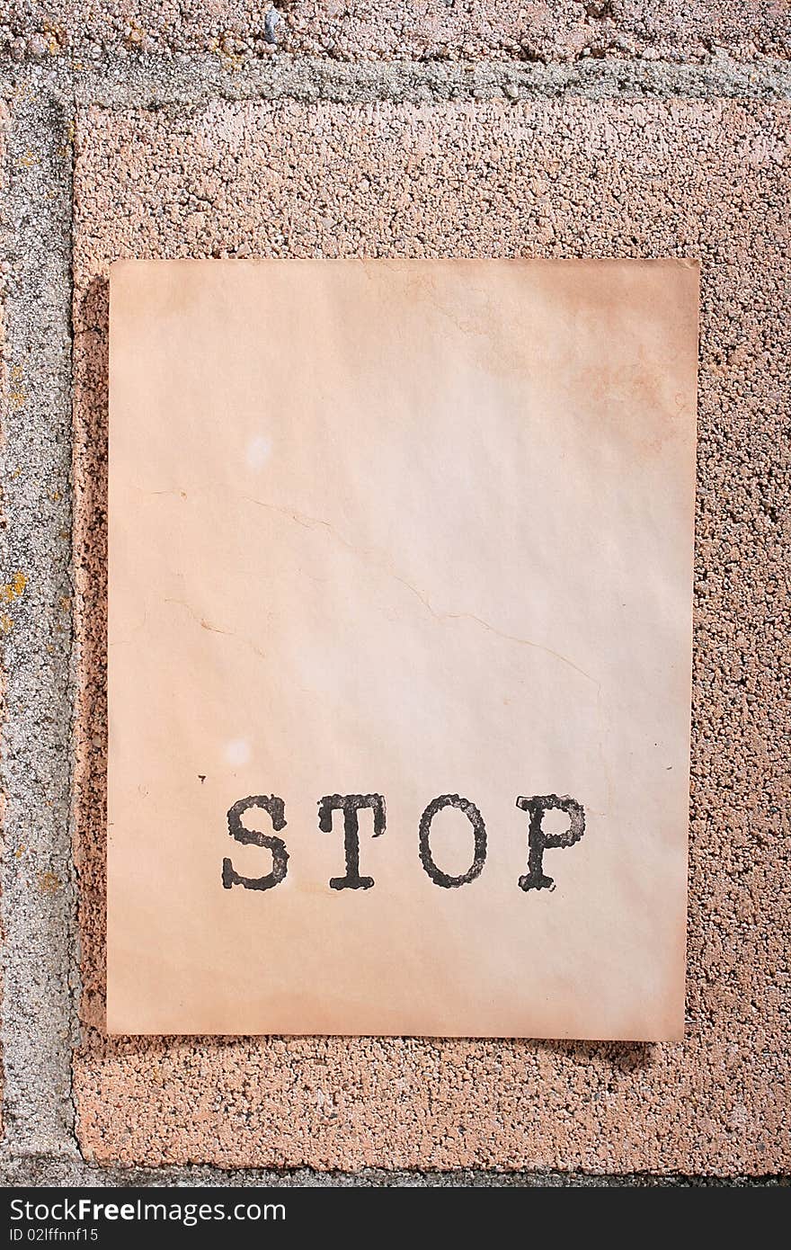 The old announcement on a wall from concrete blocks with inscription STOP. The old announcement on a wall from concrete blocks with inscription STOP.