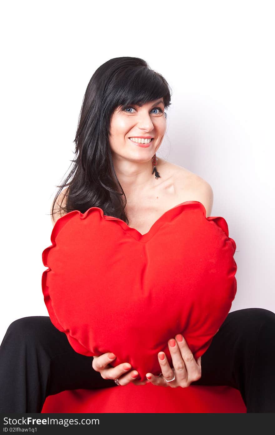 Woman offering a heart shpaed pillow. Woman offering a heart shpaed pillow