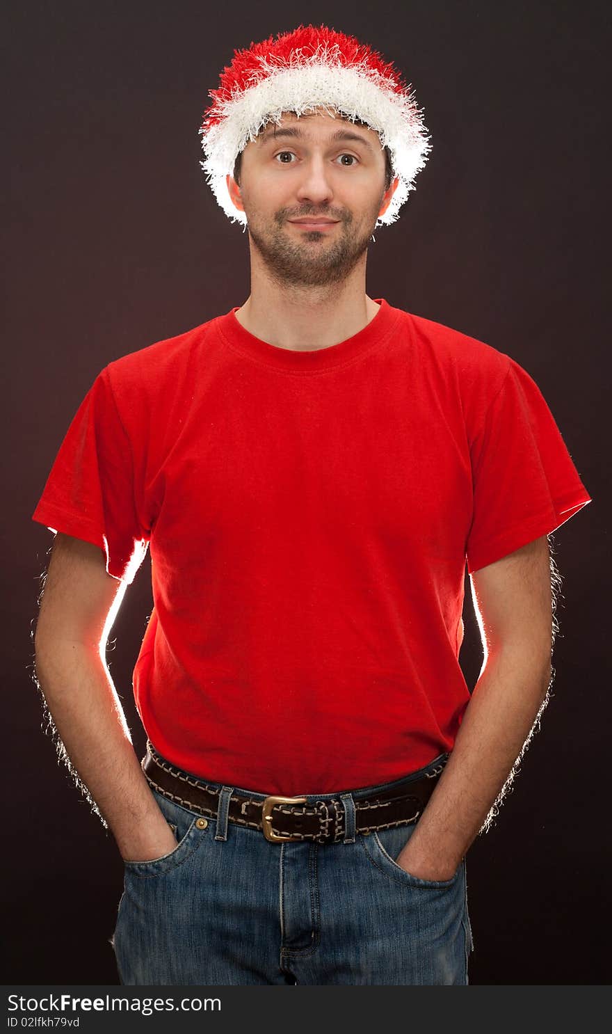 Bad santa, unshaven man in hat santa with counterohm light on dark background