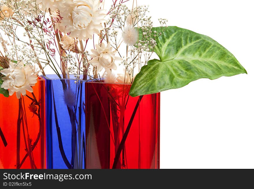 Bouquet from dry herb and green sheet in colour glass vase on white background