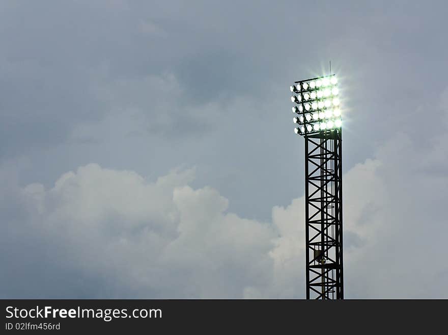 Spotlight of football stadium is lighting up beautiful background cloud. Spotlight of football stadium is lighting up beautiful background cloud