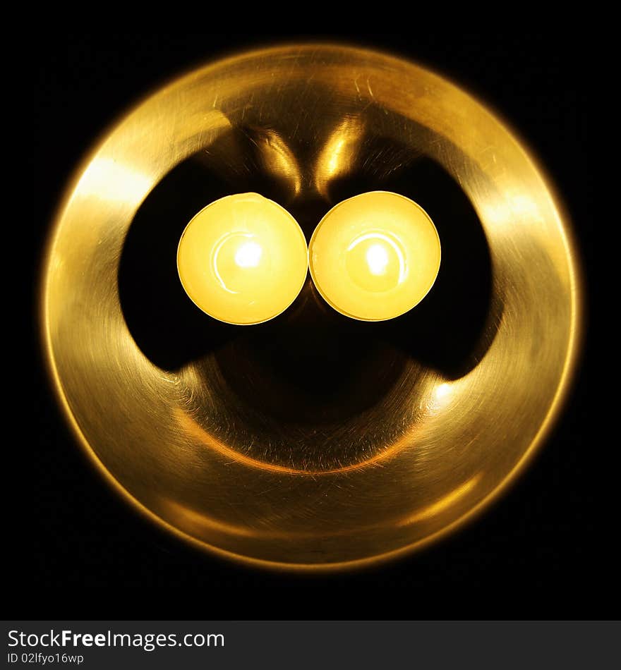 Photo of glowing smiley made of a bowl and two candles