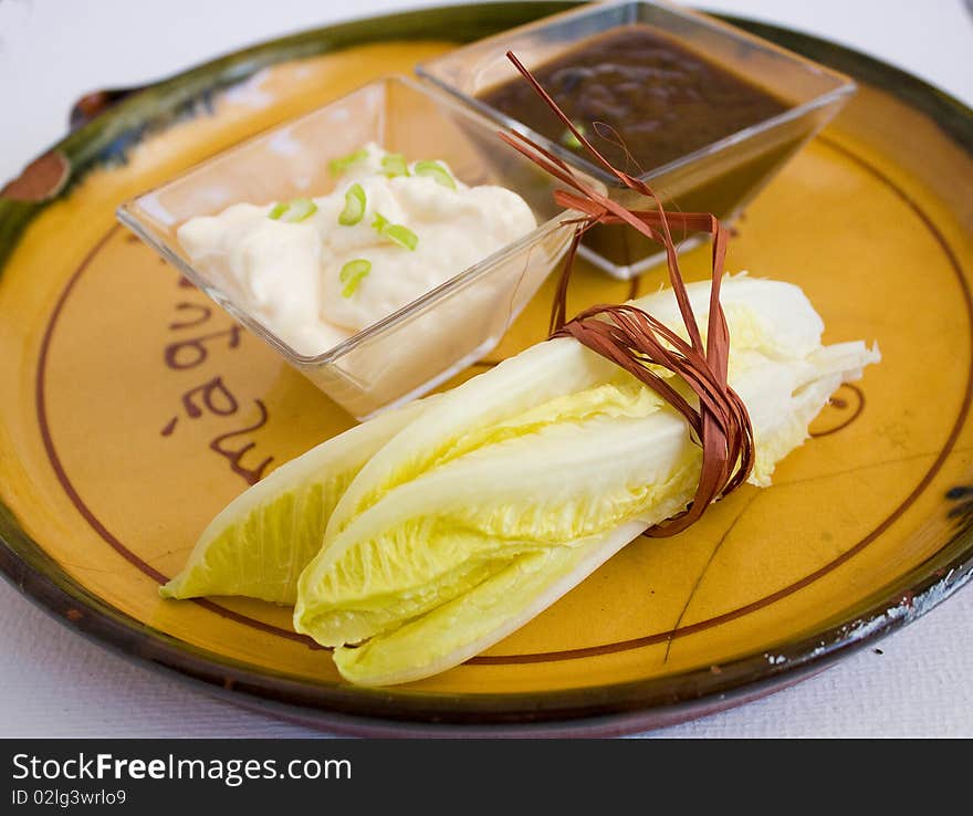 Salad leaves on a plate with white and red sauce. Salad leaves on a plate with white and red sauce