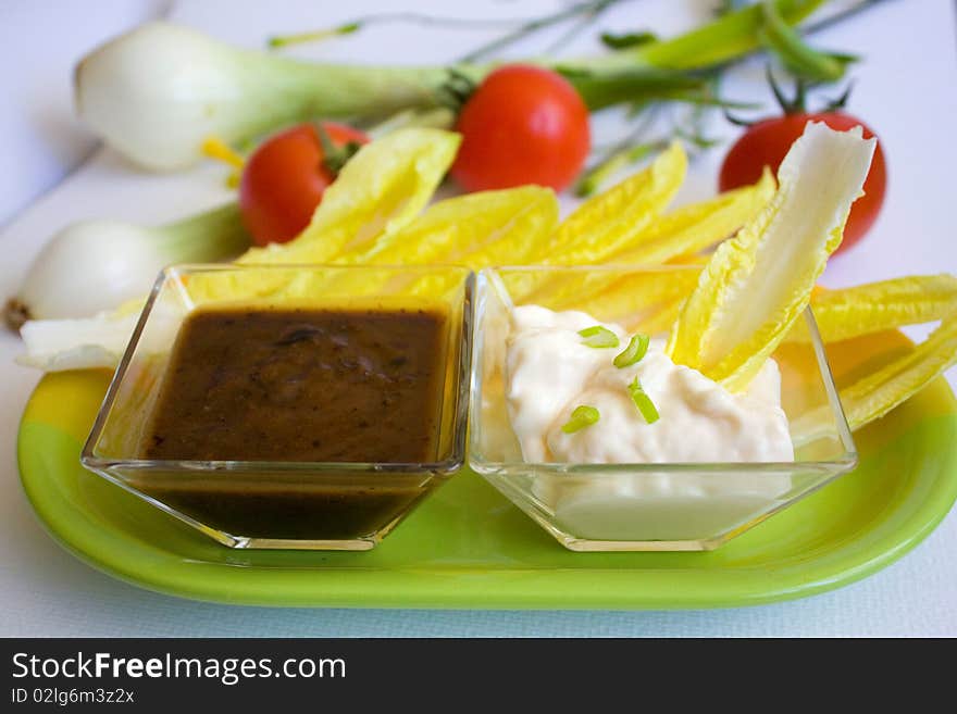 Salad leaves on a plate with white and red sauce. Salad leaves on a plate with white and red sauce