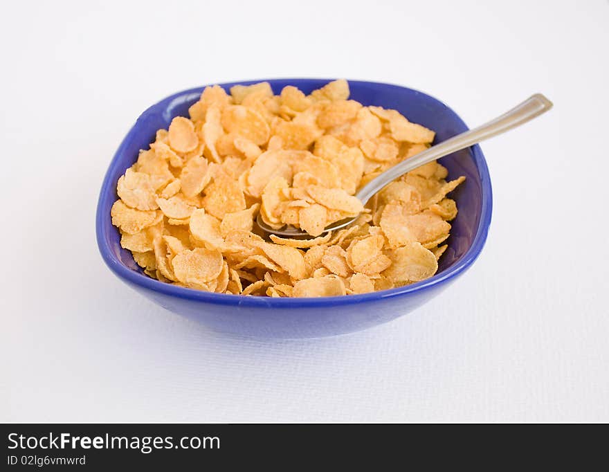 Cornflakes in the blue plato with spoon. Cornflakes in the blue plato with spoon.