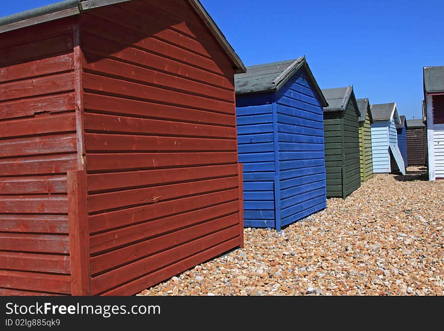 Rear of a row of beachhuts on a pebbled beach