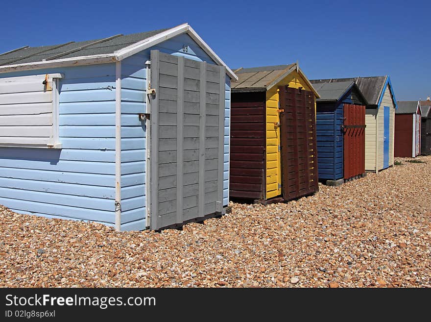 A row of locked beachhuts on a pebble beach in England