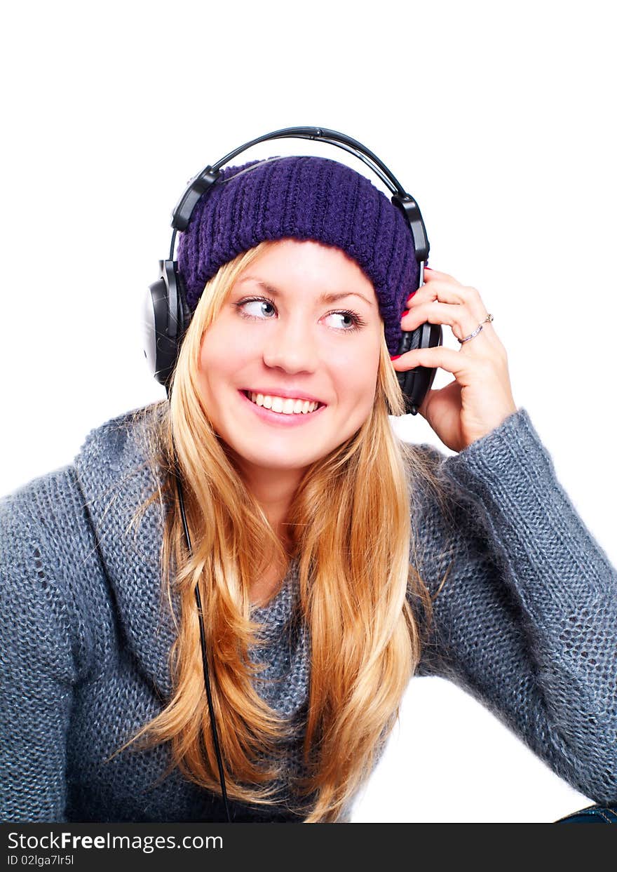 Smiling blond woman with headphones listening music over white