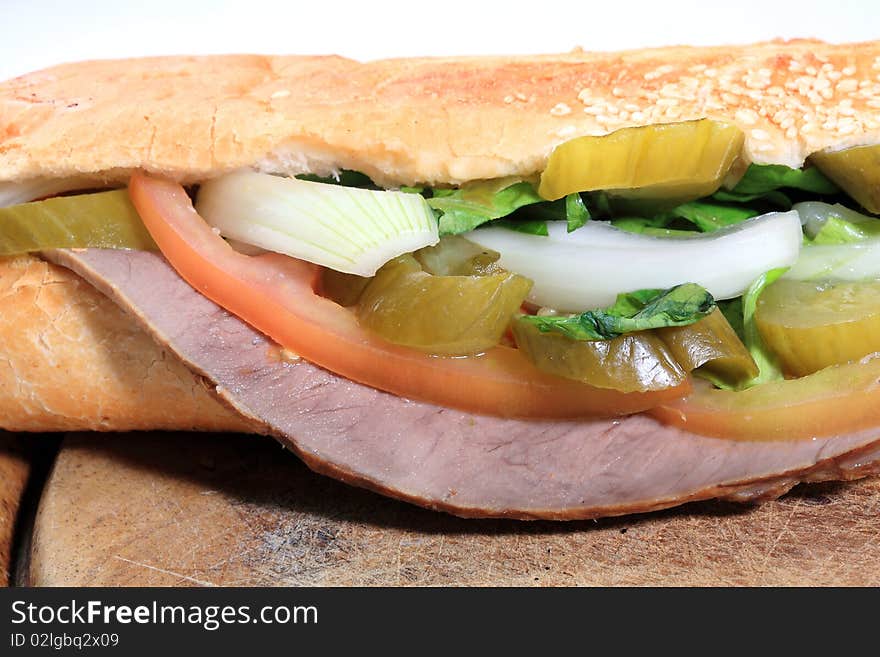 Close up salami sandwich with pickles tomato