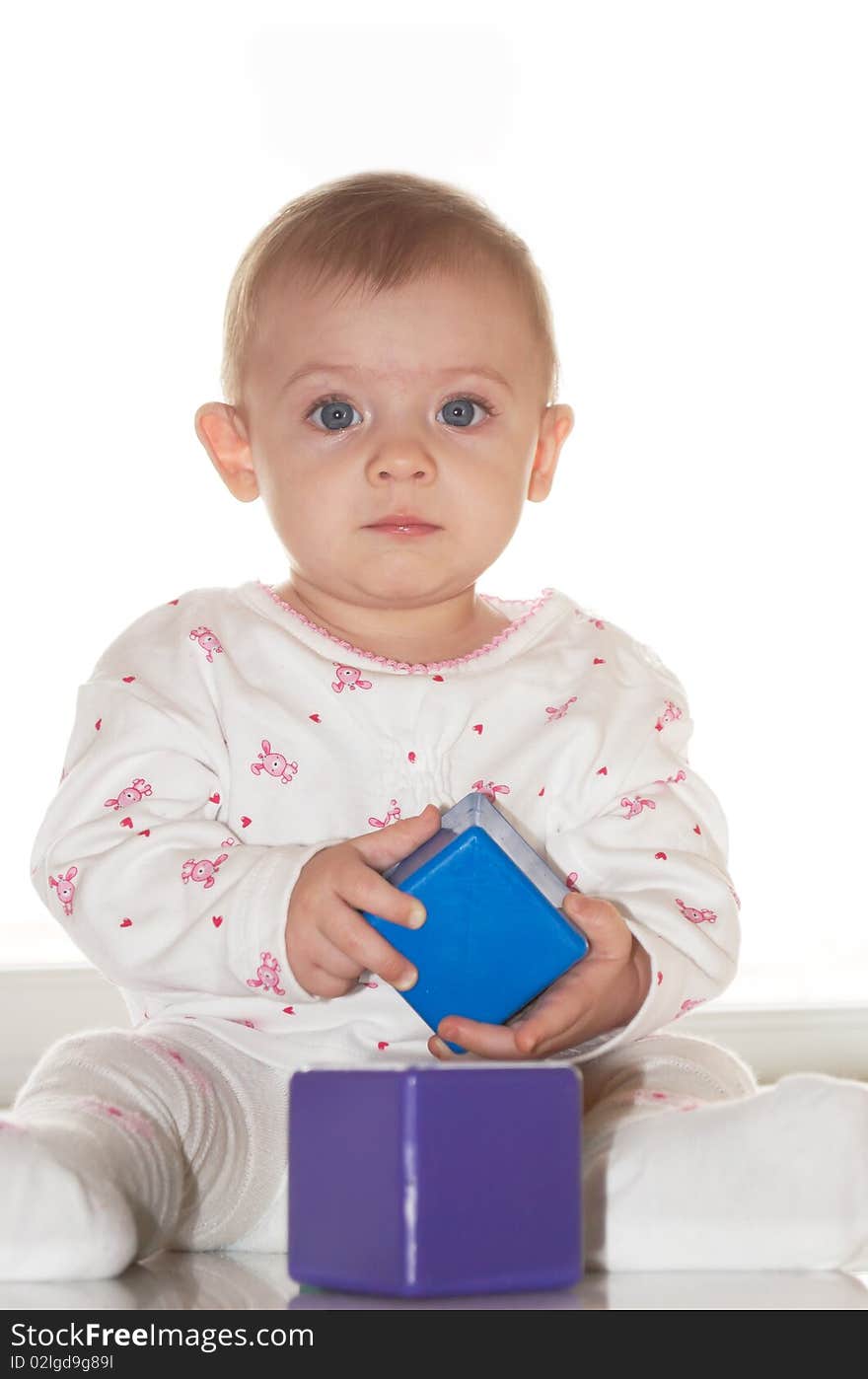 The small child sits with cubes. The small child sits with cubes