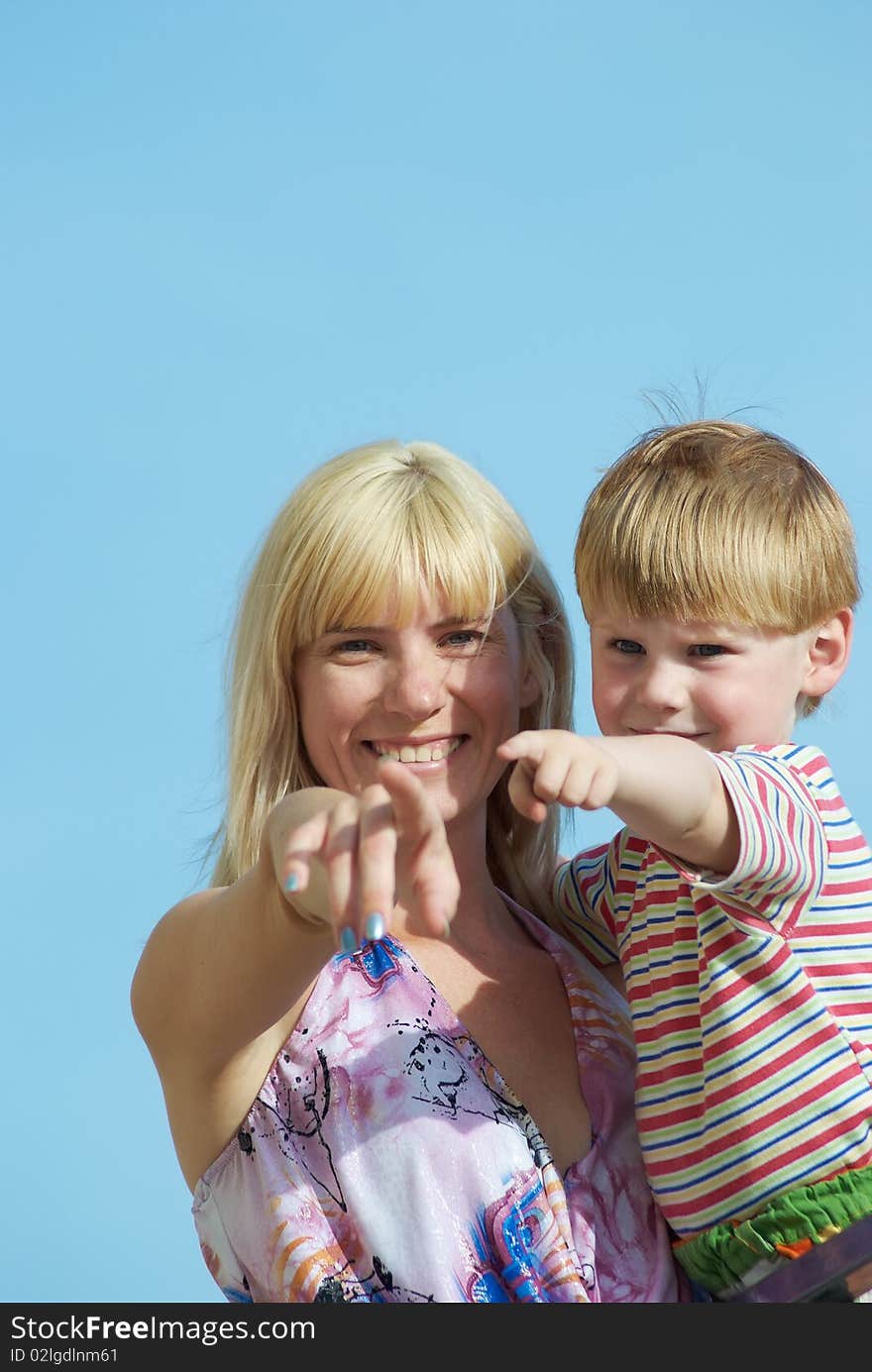 Mum with the small son on hands on a background of the dark blue sky. Mum with the small son on hands on a background of the dark blue sky