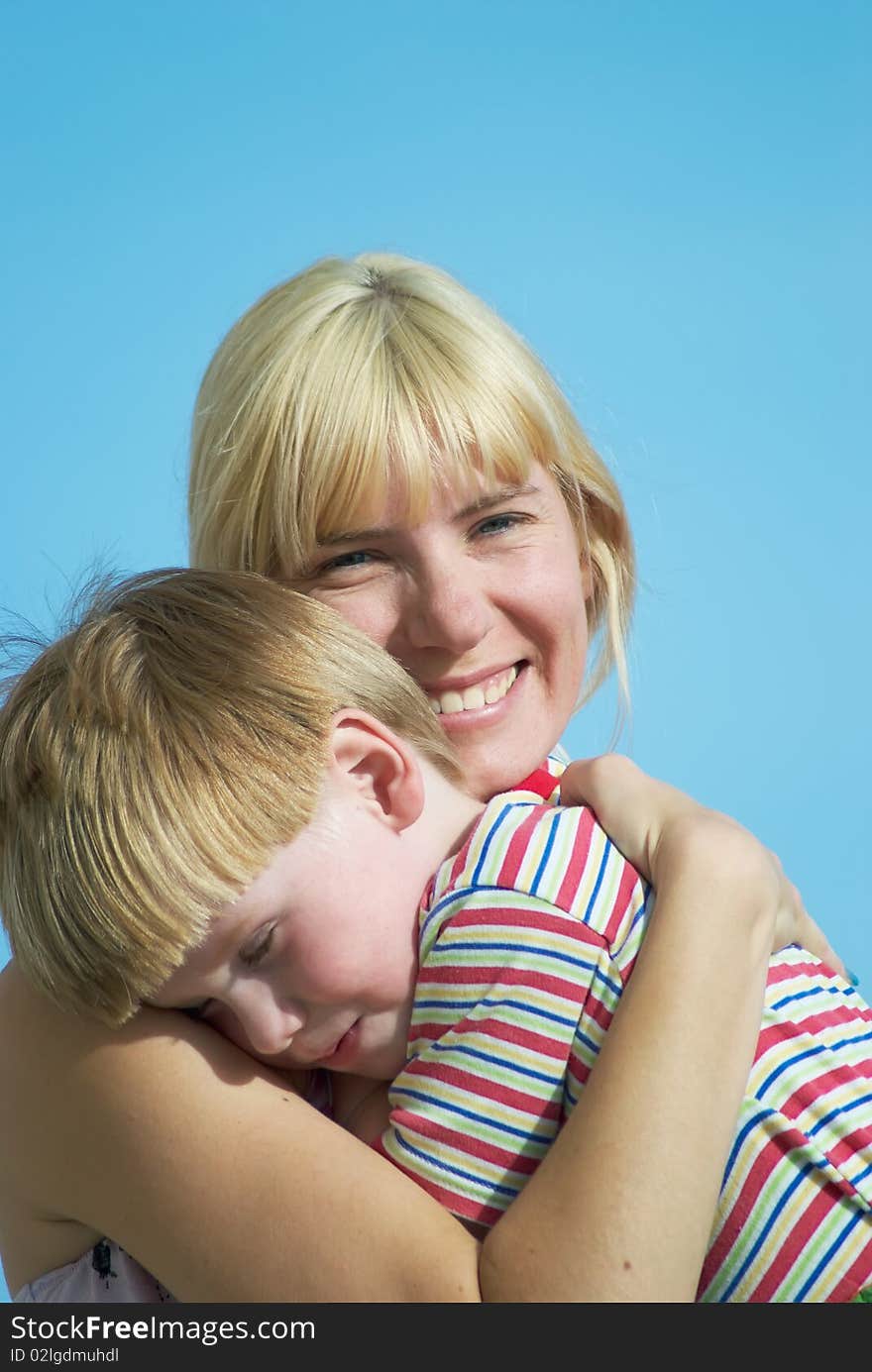 Mum with the small son on hands on a background of the dark blue sky. Mum with the small son on hands on a background of the dark blue sky