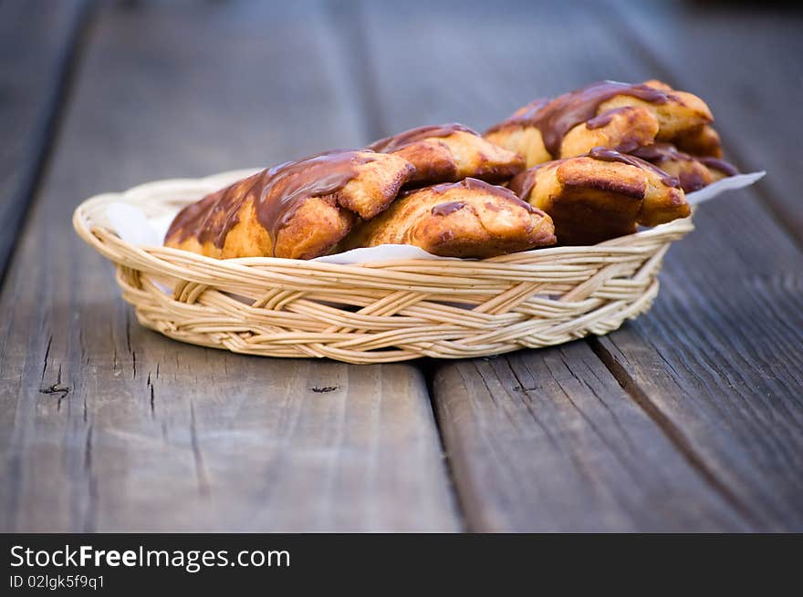 Chocolate Buns In A Wicker Basket On Wood Boards