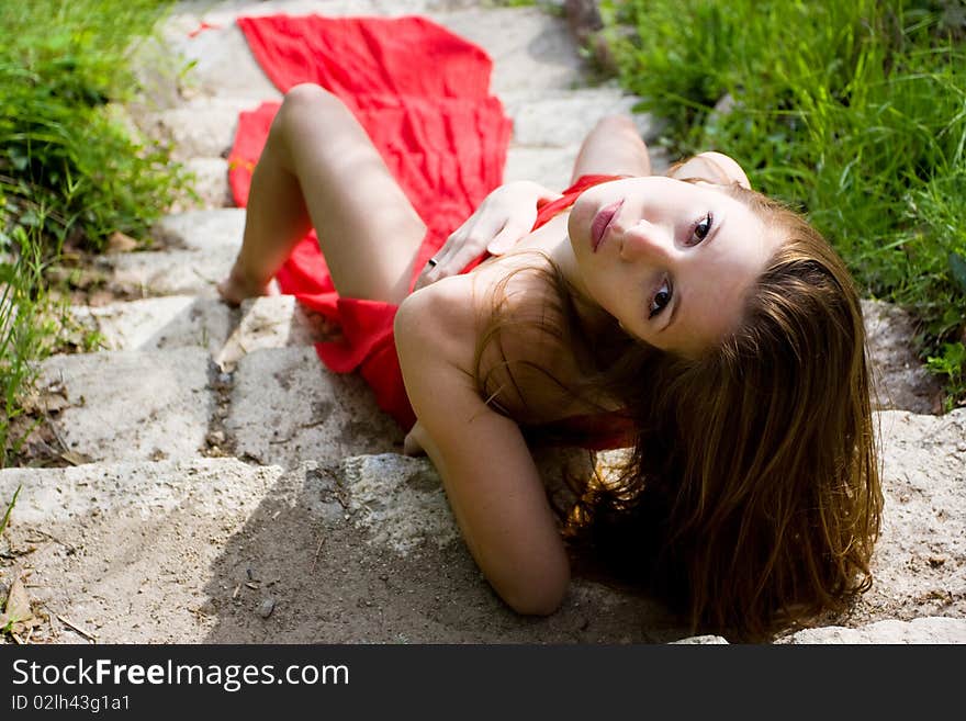 Woman in red dress from material and rocks