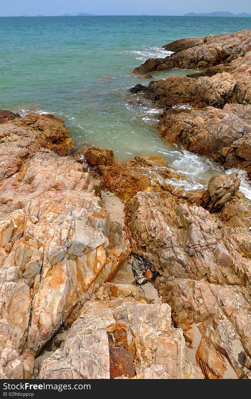 Reef in yellow and brown color on beach, the reef is extend to blue sea. Reef in yellow and brown color on beach, the reef is extend to blue sea.