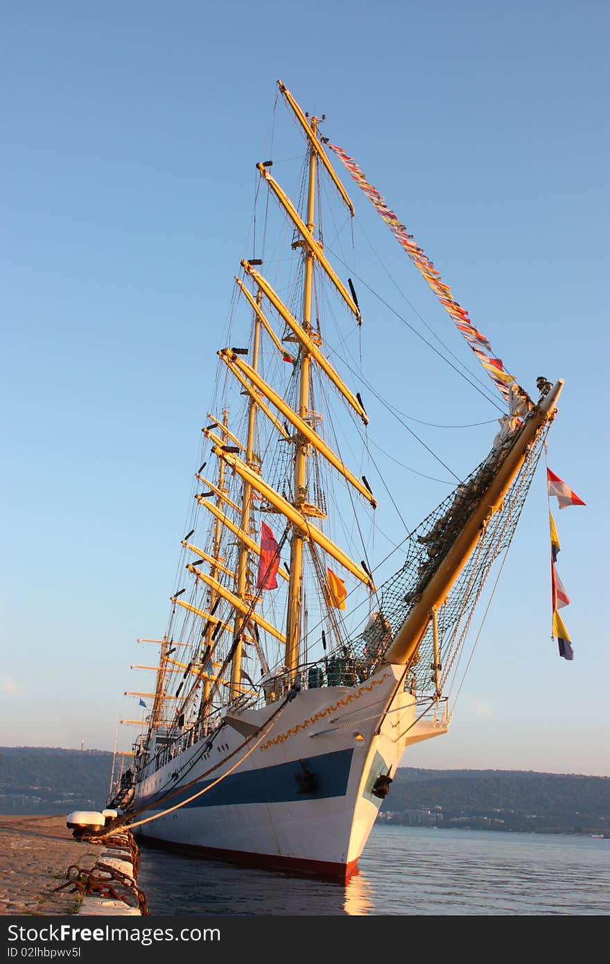 A frigate berth on a dock with a blue sky and sea landscape