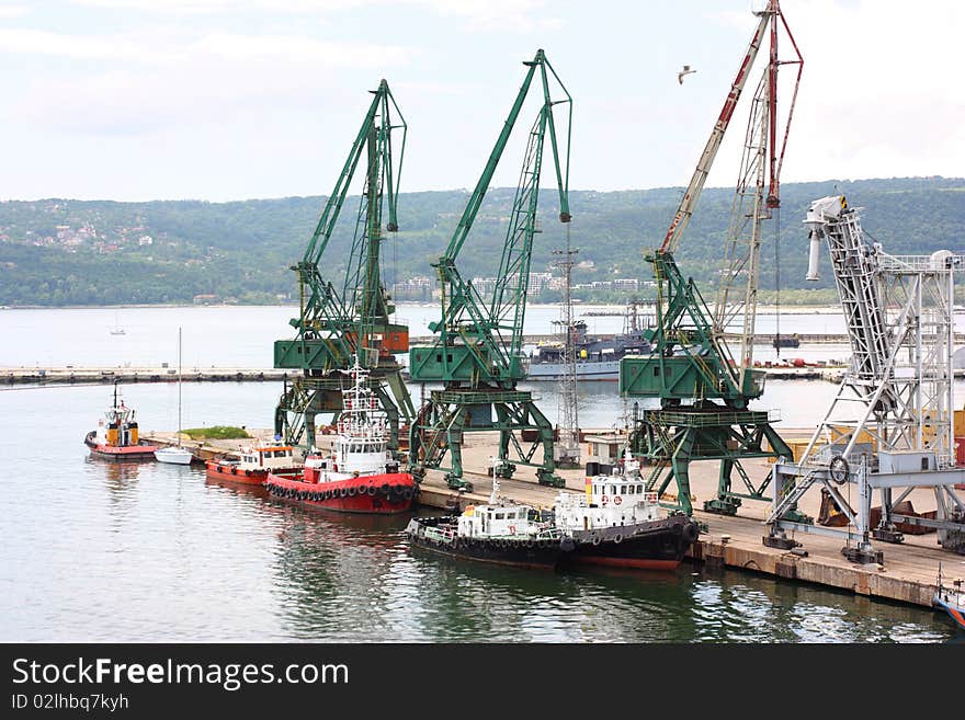 A port with tugboats and cranes. A port with tugboats and cranes