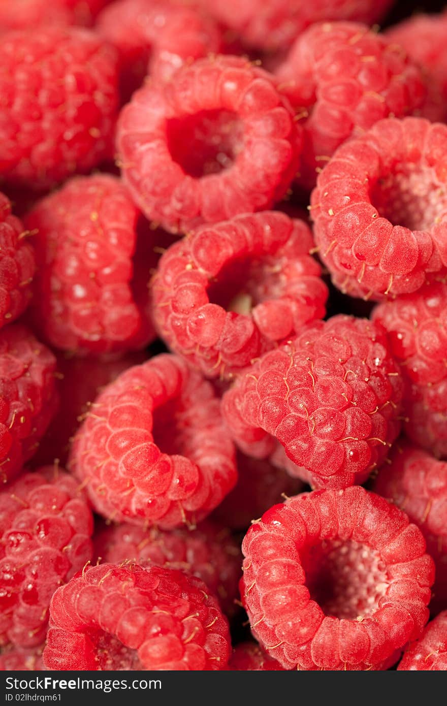 A macro shot of a heap of raspberries.