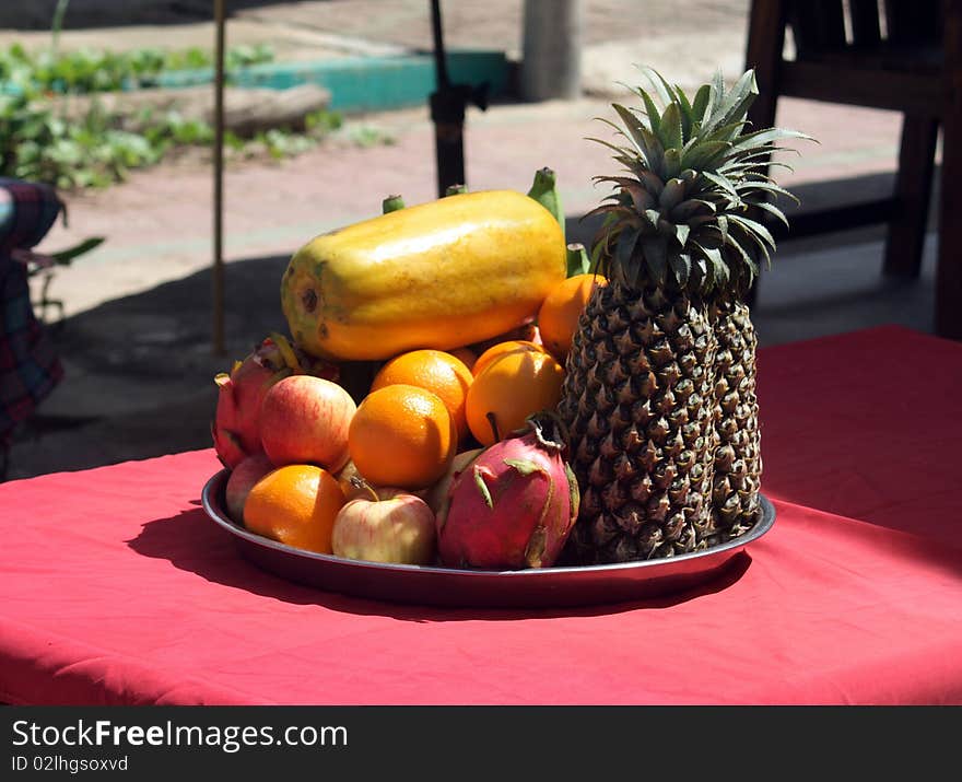 Tropical fruits on table, pineapple, oranges, apple etc