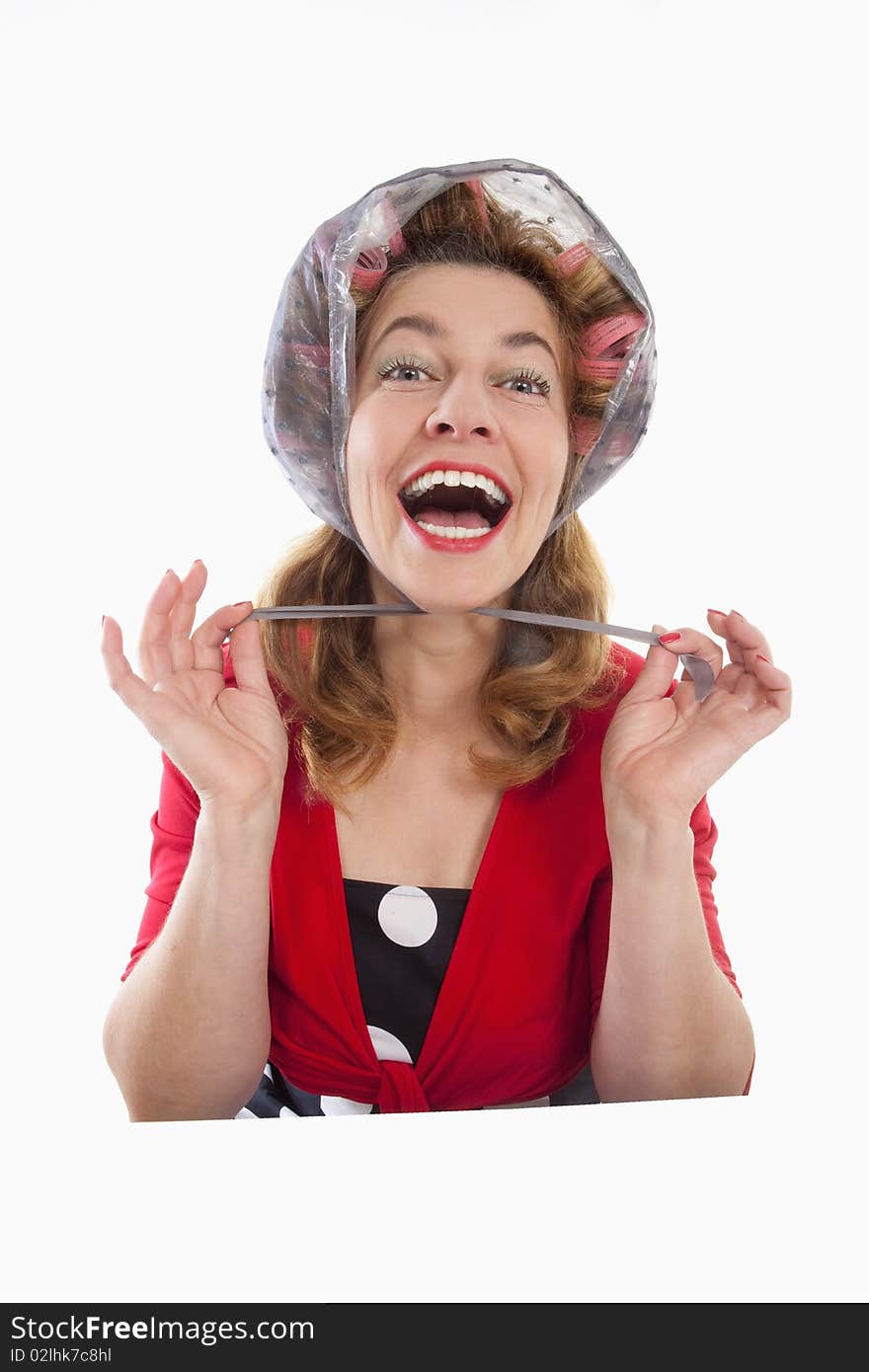 Happy middle-aged woman in red with hair rollers - isolated on white. Happy middle-aged woman in red with hair rollers - isolated on white