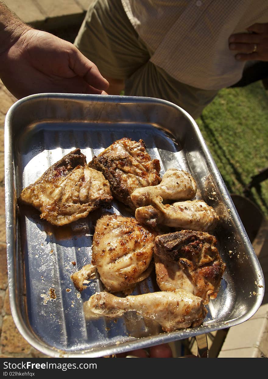 Grilling chicken drumsticks and pieces in a  bbq tray. Grilling chicken drumsticks and pieces in a  bbq tray