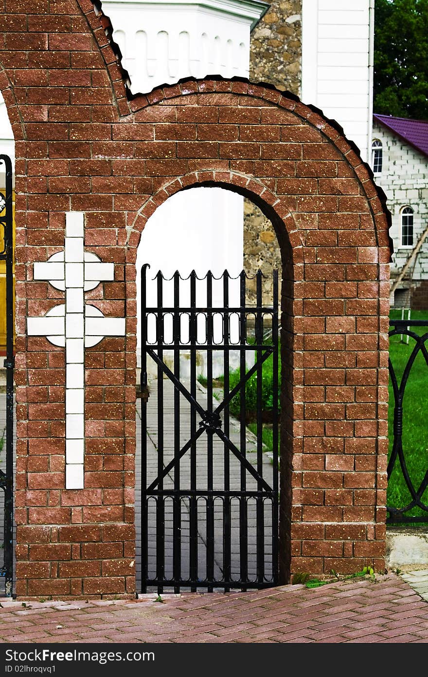 Brick gate with a cross conducting in a building churches. Brick gate with a cross conducting in a building churches