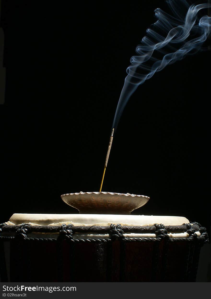 Burning aromatic stick on drum