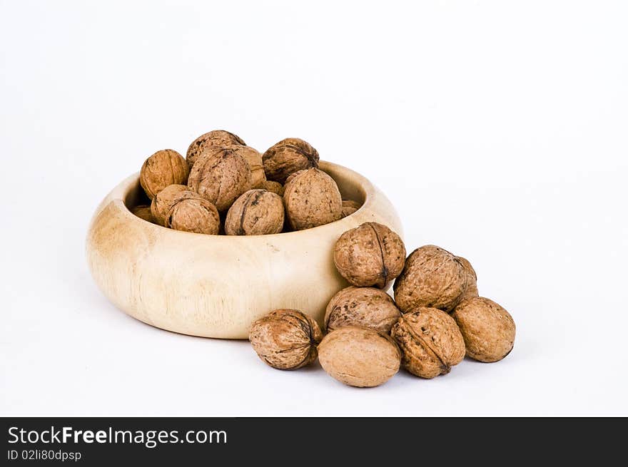 Walnuts in wooden bowl on white background