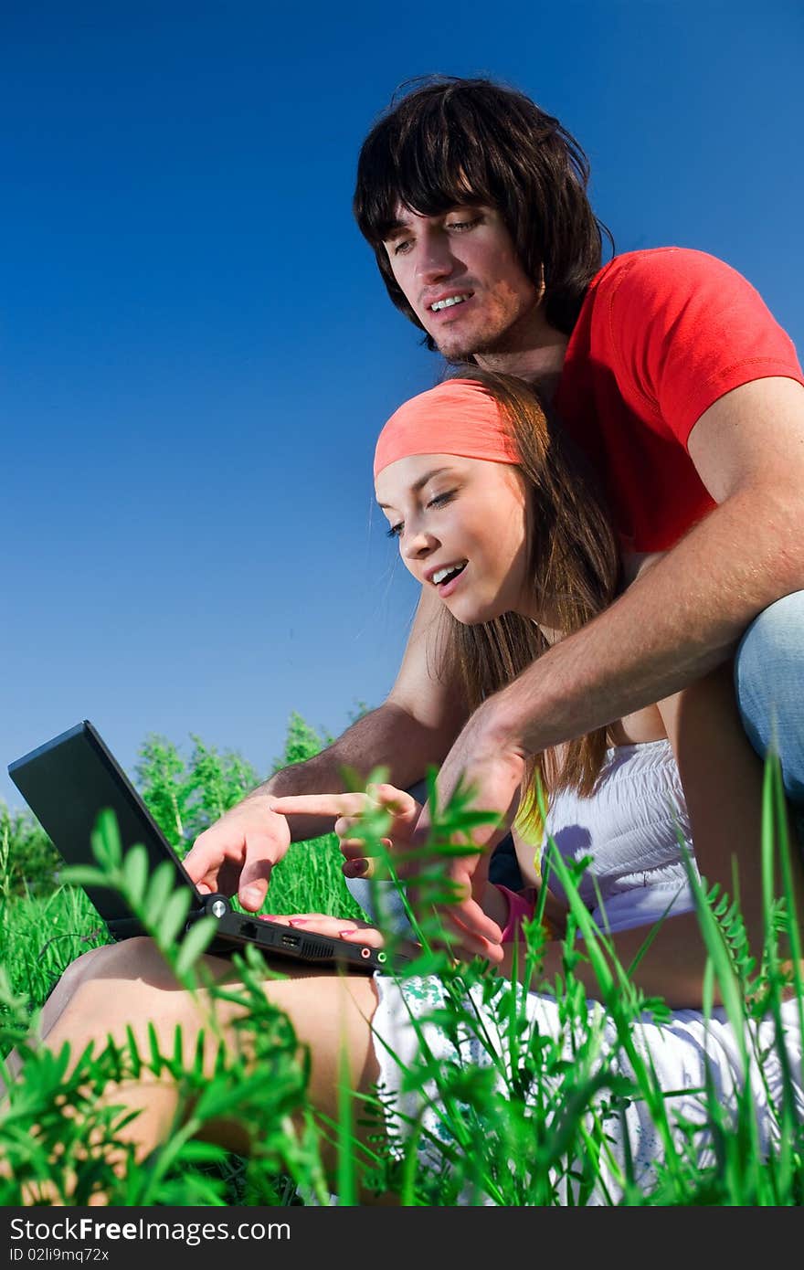 Boy and beautiful girl with notebook on grass. Boy and beautiful girl with notebook on grass