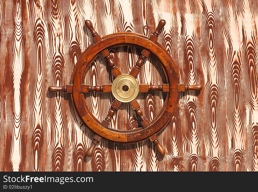 A steering-wheel on a wooden background