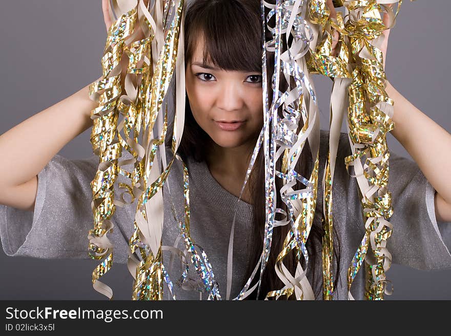 Girl standing among tinsel studio shot