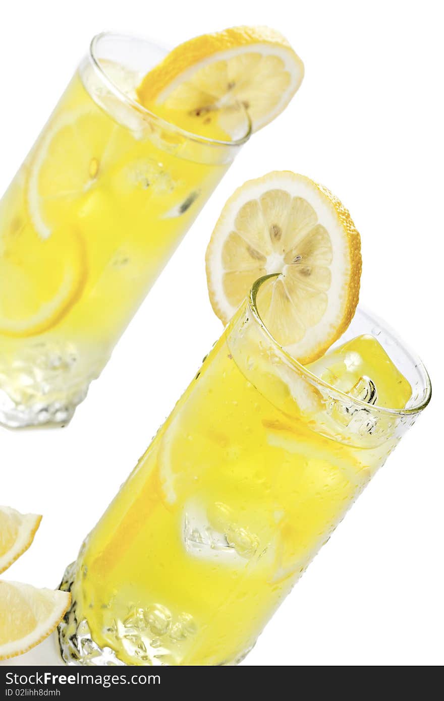 Glass of freshly made cold lemon beverage with pieces of the fruit. Glass of freshly made cold lemon beverage with pieces of the fruit