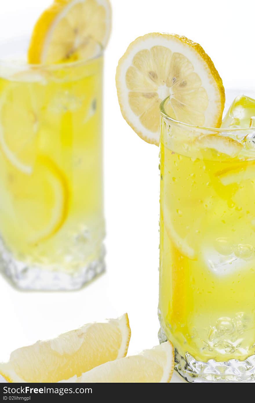 Glass of freshly made cold lemon beverage with pieces of the fruit. Glass of freshly made cold lemon beverage with pieces of the fruit