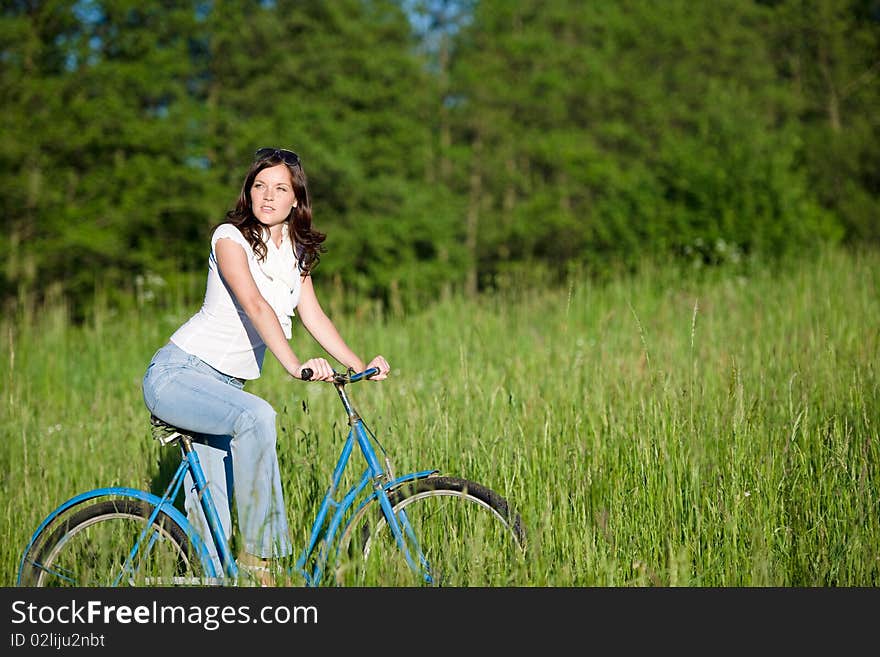 Woman with old-fashioned bike in meadow