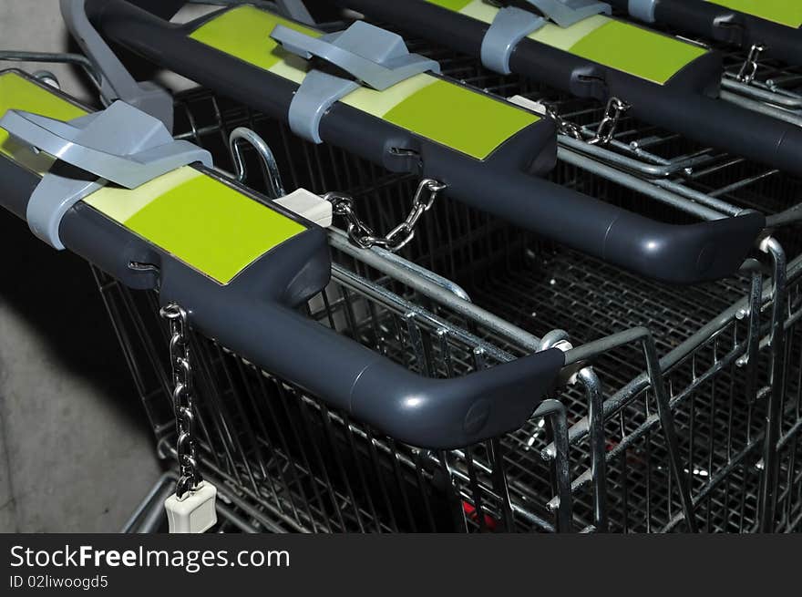 Detail of some shopping trolleys standing in a row. Detail of some shopping trolleys standing in a row