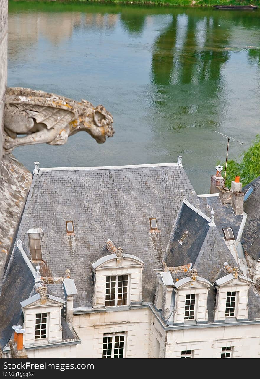 An old gargoyle watches serenely above a french village on the Indre river. An old gargoyle watches serenely above a french village on the Indre river.