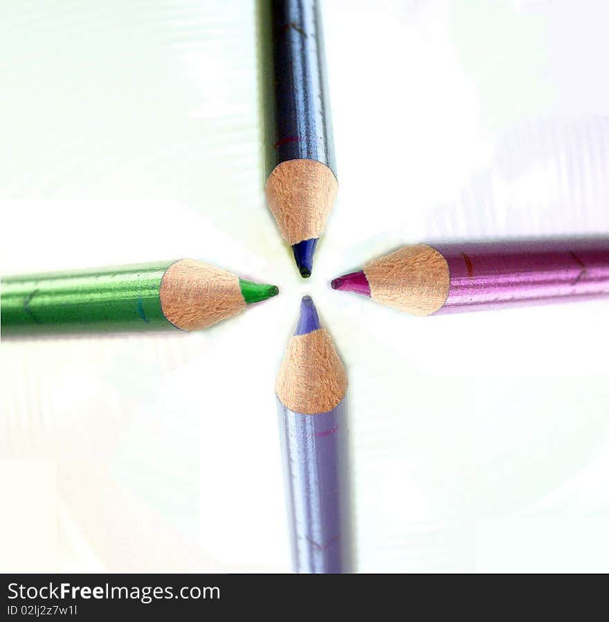 Four crayons in different colours, green, red, black and violet