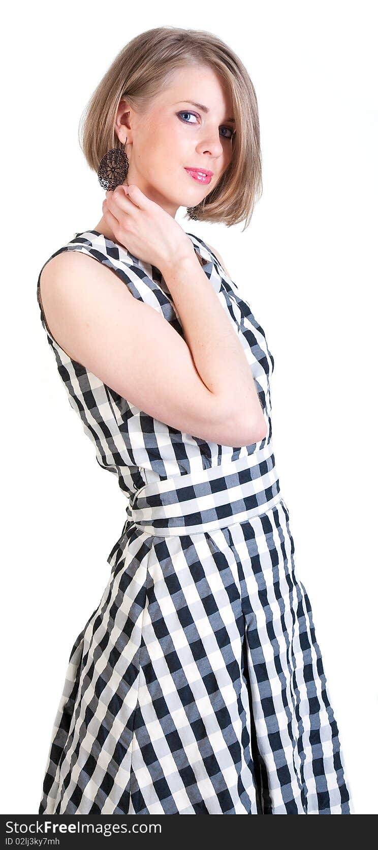 Beautiful girl in earrings in a dress in a cage (isolated). Beautiful girl in earrings in a dress in a cage (isolated)