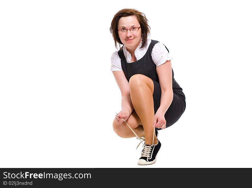 Female, office worker ties her sporty shoes, studio shoot isolated on white background. Female, office worker ties her sporty shoes, studio shoot isolated on white background