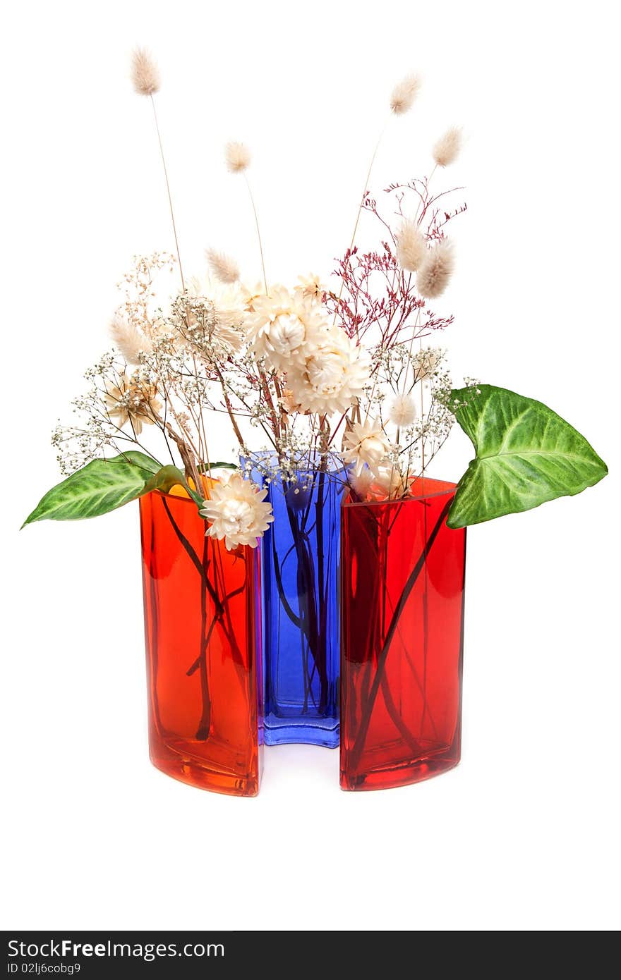 Bouquet from dry herb and green sheet in colour glass vase on white background