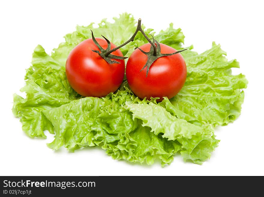 Two ripe tomatoes on sheet of the salad