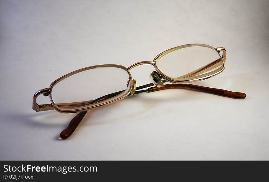 A pair of reading glasses with thin frame and plastic lenses.