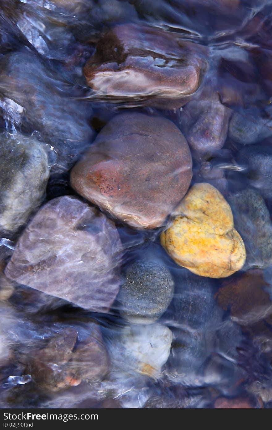 Coloured pebbles in running water